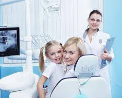 Mother daughter on a dental chair with assistant